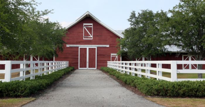 Red barn with fence lined driveway
