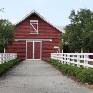 Red barn with fence lined driveway