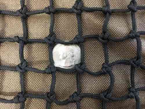 A quarter sits inside 3/4" slow feed hay net mesh to show how large the openings are.