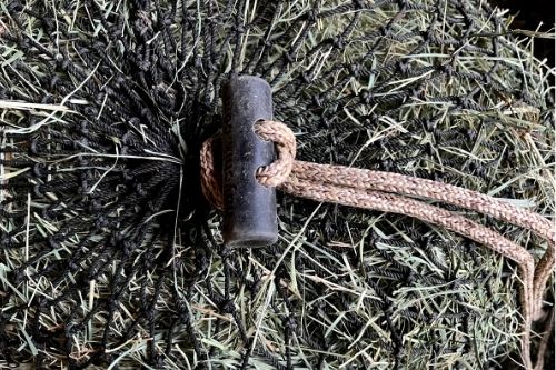 Hay net drawstring closure. Tie half hitch knot at the base of the rubber "hoggle"