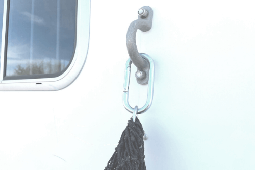 Showing hay net carabiner clip attached to a horse trailer  eye strap.
