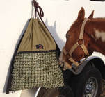 Horse eating from Hanging Hay Pillow slow feeding bag at horse trailer
